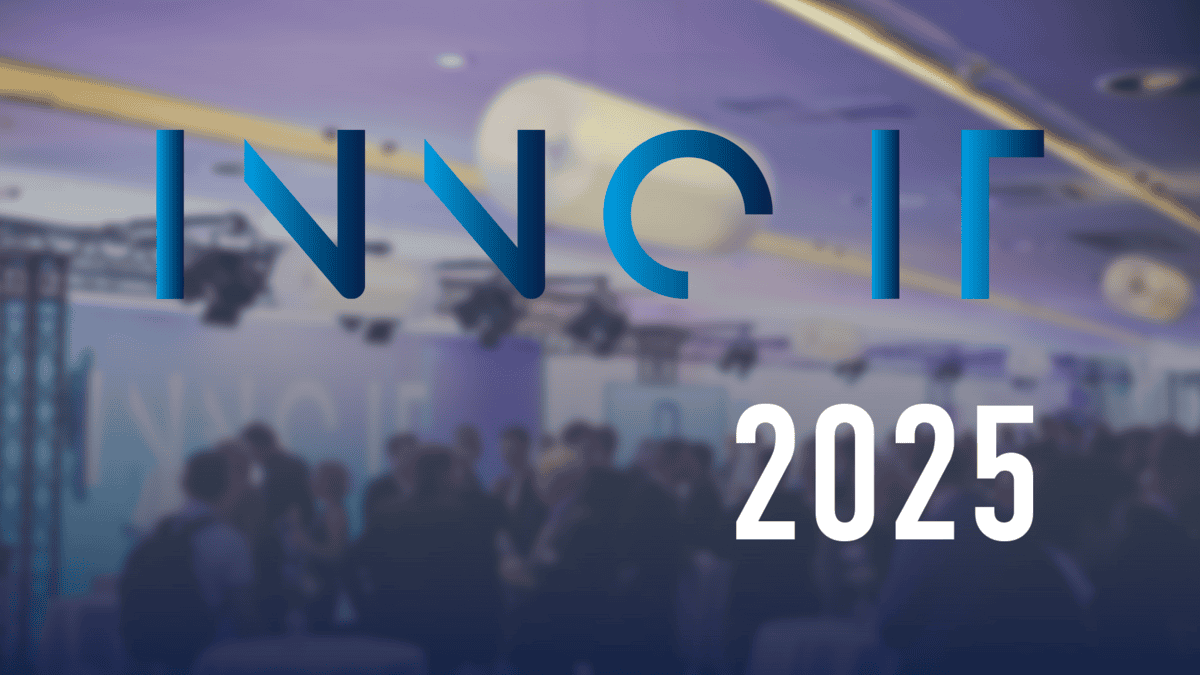 Veranstaltungsraum mit mehreren Personen im Gespräch, darüber der Schriftzug „INNO IT 2025“ in blau und weiß, symbolisiert Innovation und Digitalisierung im IT-Bereich.