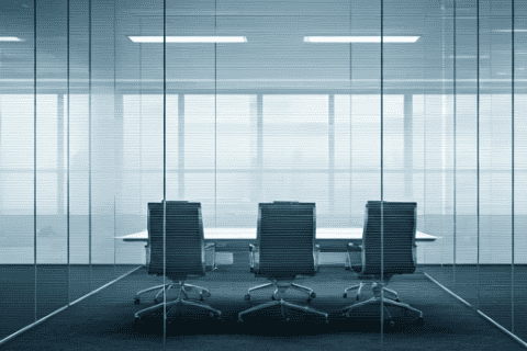 Moderner, heller Besprechungsraum mit Glaswänden, drei ergonomischen Bürostühlen vor einem weißen Konferenztisch, minimalistisches Design, repräsentativ für professionelle IT-Beratung und Kommunikationstechnik in einem IT-Systemhaus.