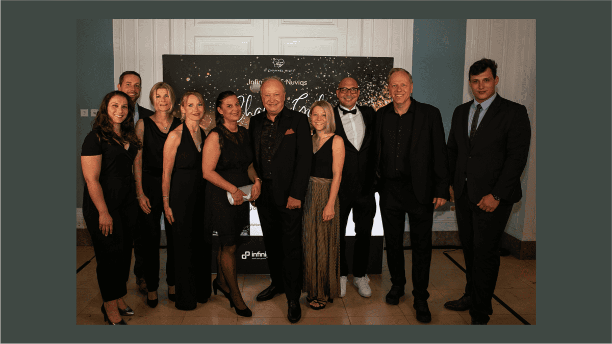 Zehn Personen in eleganter Abendkleidung stehen vor einer Fotowand mit goldenen Sternen und dem Schriftzug „Infinity Nuvias Charity Gala“. Die Gruppe lächelt in die Kamera, im Hintergrund sind Logos von Infinity und Nuvias zu sehen. Die Szene vermittelt einen festlichen Anlass, passend zu professionellen Netzwerken und Events.