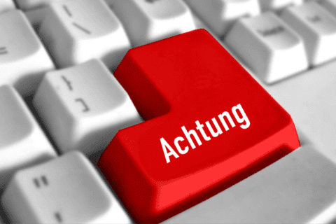 Tastatur mit einer roten Taste, auf der in weißer Schrift „Achtung“ steht, umgeben von weißen Tasten.
