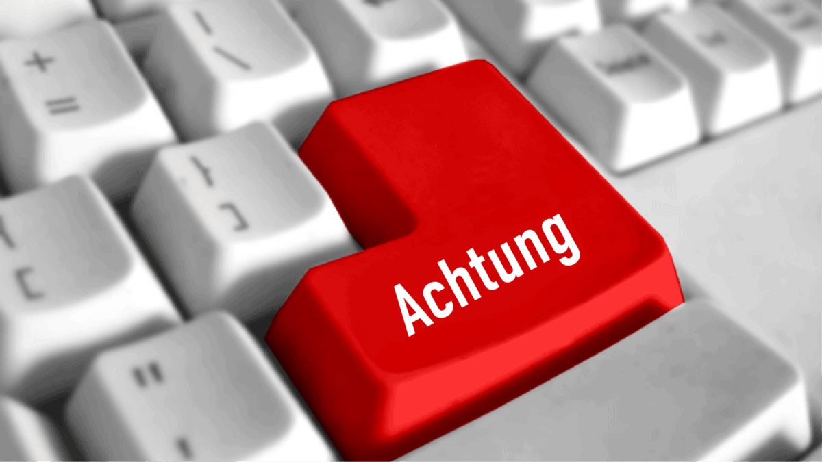 Tastatur mit einer roten Taste, auf der in weißer Schrift „Achtung“ steht, umgeben von weißen Tasten.