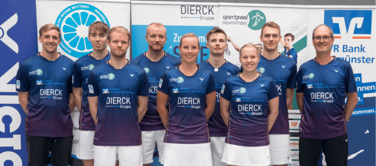 Acht Personen in einheitlichen Sporttrikots mit dem Schriftzug „dierckgroup“ stehen nebeneinander vor Werbebannern, die unter anderem die dierckgroup, Sportpool Neumünster und VR Bank Neumünster zeigen. Die Trikots sind dunkelblau mit lila Akzenten, die Personen wirken als Team, passend zum Kontext von IT Solutions und Managed Services der dierckgroup.