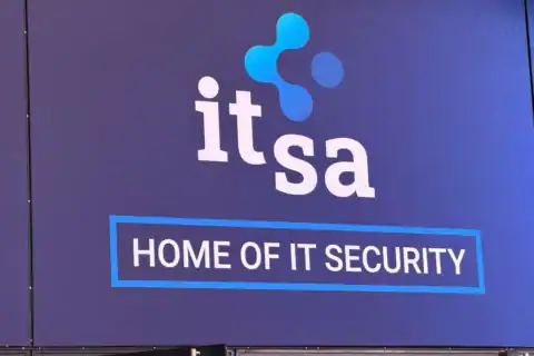 Logo der it-sa auf blauem Hintergrund mit dem Schriftzug „HOME OF IT SECURITY“ in einem blauen Rahmen, Hinweis auf IT-Security und Digitalisierung.